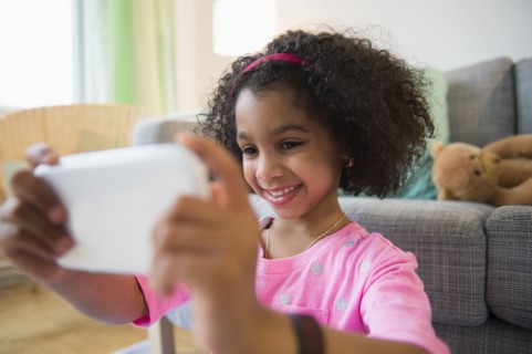 African American girl taking pictures with cell phone