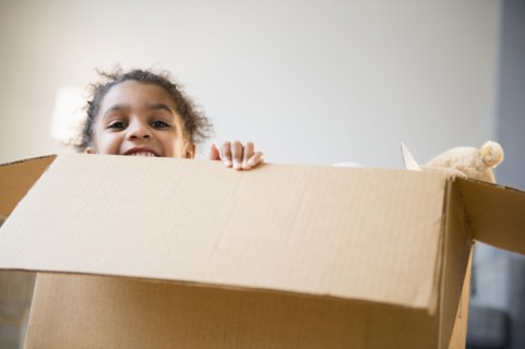 African American girl playing in cardboard box