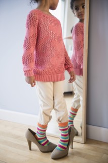 African American girl dressing up in mother's shoes