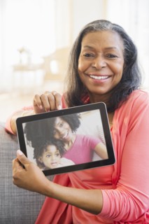 Mixed race woman using tablet computer on sofa
