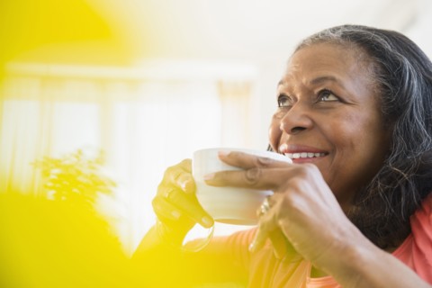 Mixed race woman drinking cup of coffee