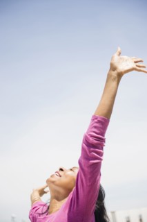 Mixed race woman with arms outstretched outdoors