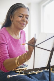 Mixed race woman playing trumpet