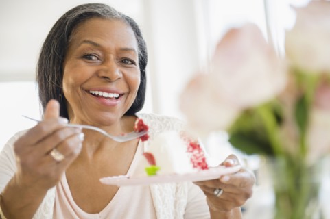 Mixed race woman sharing cake