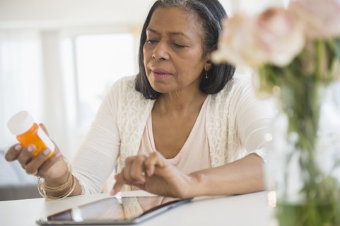 Mixed race woman researching medication on tablet computer