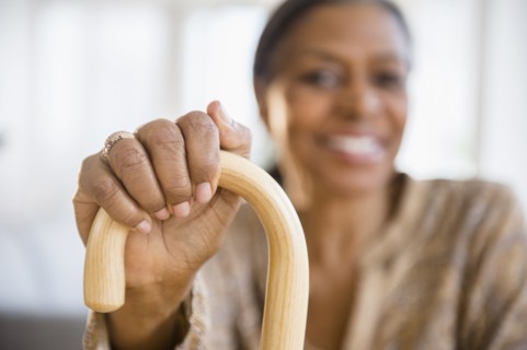 Mixed race woman holding cane