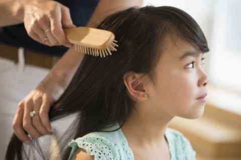 Mother brushing daughter's hair