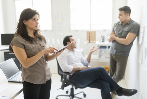 Hispanic businesswoman using tablet computer in office