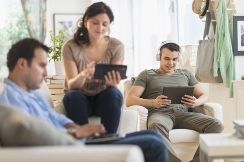 Hispanic friends using technology in living room