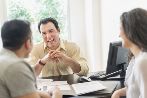 Hispanic businessman talking to clients in office