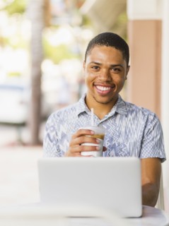 African American man using laptop in cafe