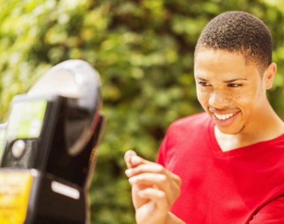 African American man paying parking meter