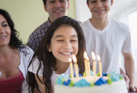 Hispanic girl admiring birthday cake