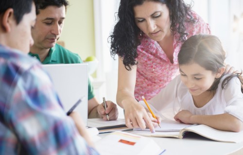 Hispanic family doing homework together at table