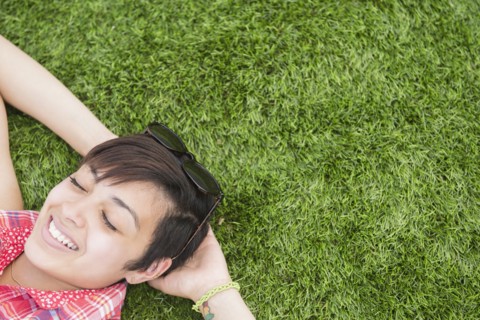 Mixed race woman laying in grass outdoors
