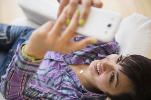Mixed race woman taking selfie with cell phone