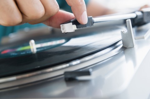 Close up of mixed race man playing vinyl record