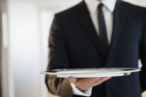 Close up of mixed race waiter holding empty tray