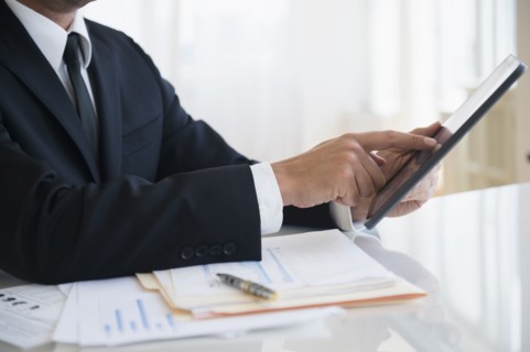 Close up of mixed race businessman using digital tablet at office desk