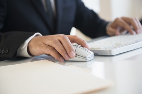Close up of mixed race businessman using wireless mouse and keyboard