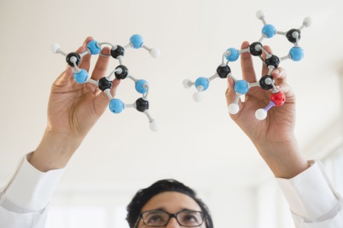 Close up of mixed race scientist holding molecular models