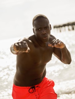 Mixed race man training on beach