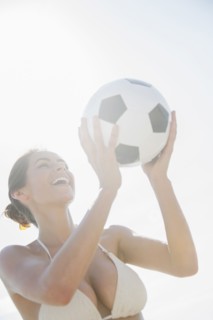 Caucasian woman holding soccer ball outdoors