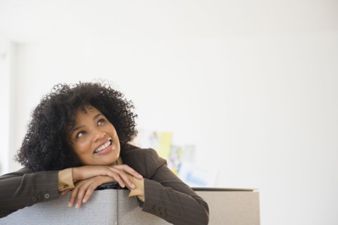 Businesswoman leaning over cubicle wall in office