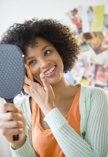 Smiling woman admiring herself in mirror
