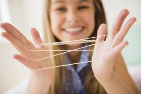 Caucasian girl playing cats cradle game