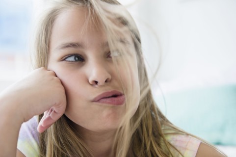 Caucasian girl blowing hair from her face