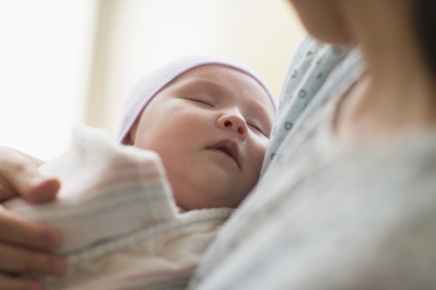 Asian mother holding newborn baby in hospital
