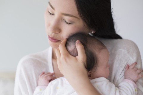 Asian mother hugging baby