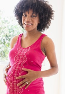 Pregnant African American mother holding her stomach