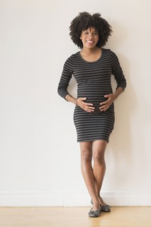 Pregnant African American mother holding her stomach