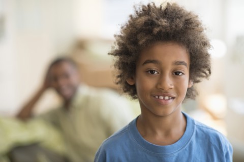 Mixed race boy smiling in living room