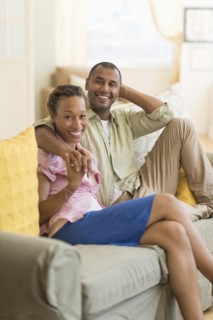 Couple smiling on sofa in living room