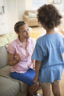 Mother talking to son in living room