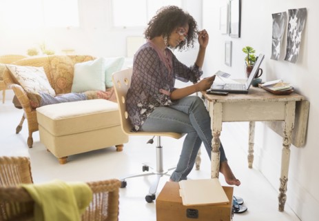 Mixed race woman using laptop in living room