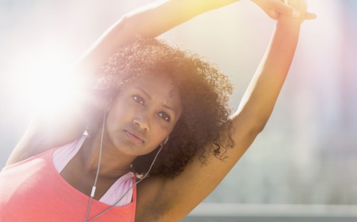 Mixed race woman stretching arms