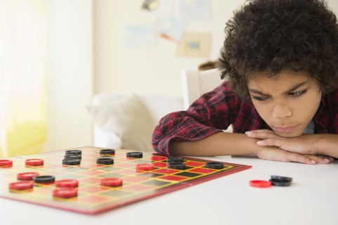 Angry mixed race boy losing game of checkers