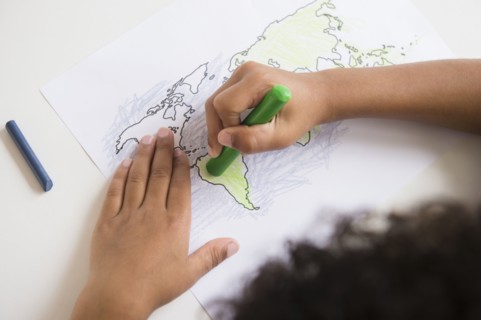 Mixed race boy coloring in world map