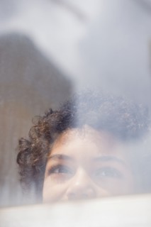 Mixed race boy looking out window