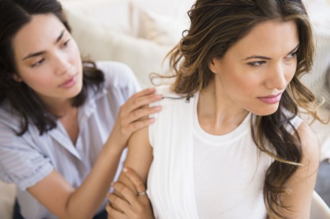 Hispanic woman comforting angry friend