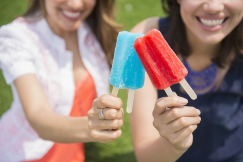 Hispanic women eating popsicles outdoors