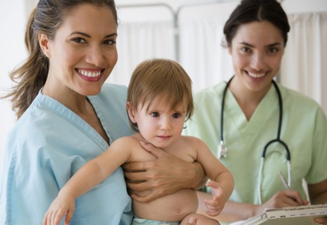 Pediatrician doctor and nurse holding baby girl in hospital