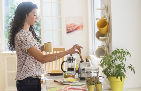 Mixed race woman preparing breakfast in kitchen
