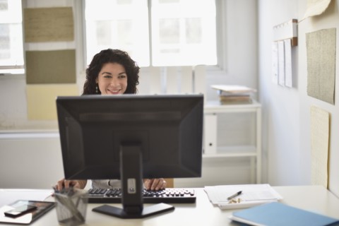 Mixed race businesswoman working on computer at desk in office