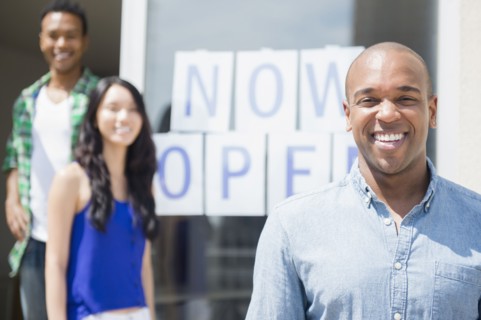 Friends smiling together by newly open storefront
