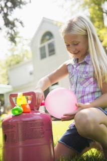 Caucasian girl filling balloons outdoors